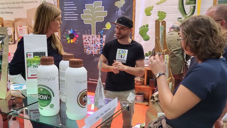 Ron Richter auf der GaLaBau Messe Nürnberg im Gespräch mit Susanne Scheer (li.), Geschäftsführerin des Natursteinzentrum Rhein Main, die klimafarmer Produkte anbieten. Foto: klimafarmer.